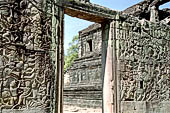 Angkor Thom - Bayon temple, east wall of the third enclosure with bas-reliefs, one of the East library is seen from the door 